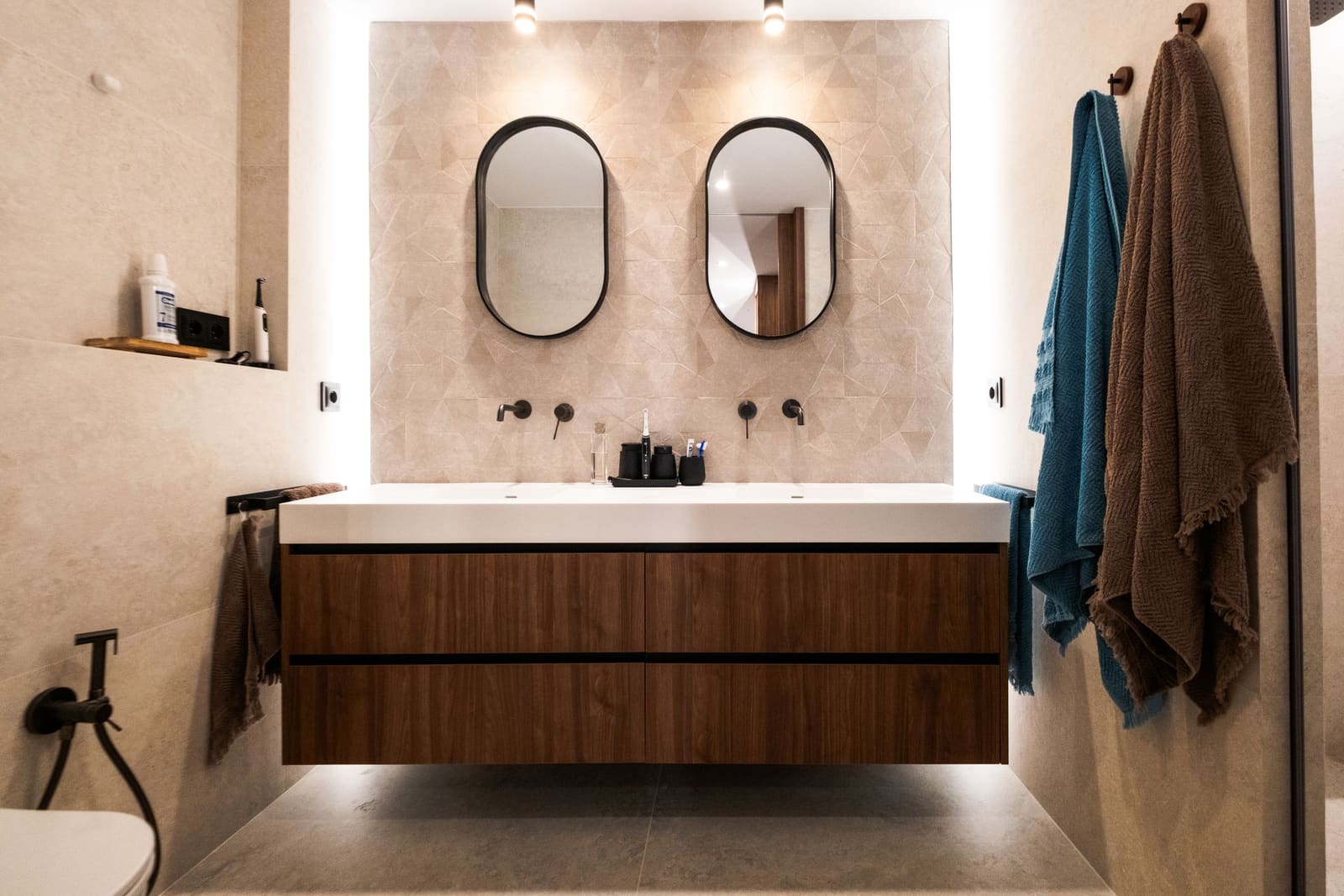 Bathroom with a double mirror and floating wood vanity in a high-end remodel